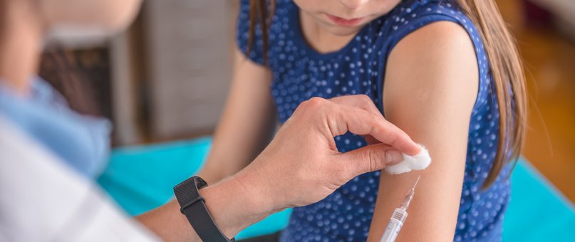 Eine Apothekerin impft ein Kind