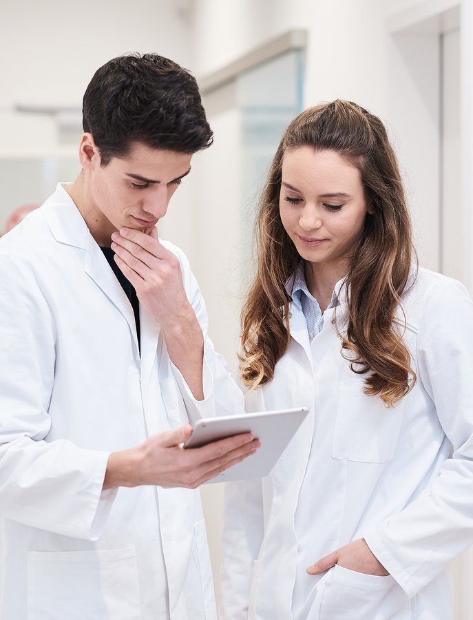 Zwei junge Apotheker:innen betrachten ein Tablet