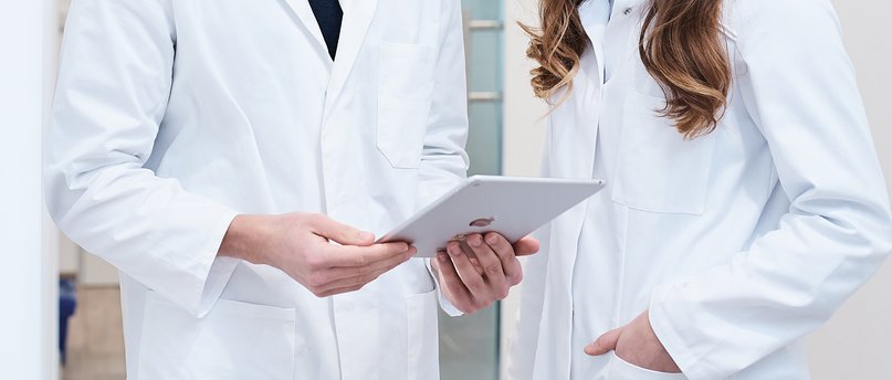 Zwei Apotheker schauen gemeinsam auf ein Tablet