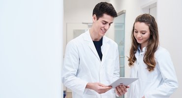 Zwei Apotheker schauen gemeinsam auf ein Tablet